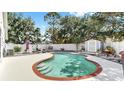 Enjoy the privacy of a refreshing kidney-shaped pool set against a backdrop of a white fence and mature trees at 11302 Crane Lake Ct, Riverview, FL 33569