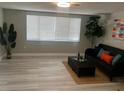 Bright living room with a large window, sleek flooring, a dark-gray sofa, and stylish décor at 12415 Stagecoach Ln, Hudson, FL 34667