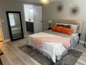 Comfortable bedroom with a queen-sized bed, modern decor, and an ensuite bathroom with dark-gray cabinets at 12415 Stagecoach Ln, Hudson, FL 34667