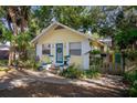 Inviting yellow home with a teal door, enhanced by lush greenery and a charming walkway at 132 21St S Ave, St Petersburg, FL 33705