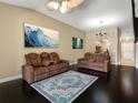 Spacious living room featuring dark wood floors, stylish furniture, ceiling fan, and elegant decor at 13313 Ashbark Ct, Riverview, FL 33579
