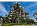 A modern multi-story condo building framed by lush tropical foliage and palm trees at 1600 Gulf Blvd # 514, Clearwater Beach, FL 33767