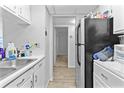 Compact kitchen featuring white cabinets, appliances, and tile flooring at 1799 N Highland Ave # 180, Clearwater, FL 33755
