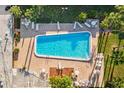 Aerial view of a rectangular pool surrounded by lounge chairs and greenery at 1799 N Highland Ave # 180, Clearwater, FL 33755