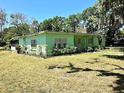 Single-story home with verdant lawn, lush bushes, and a well-maintained yard with mature trees at 1810 Alcorn Rd, Valrico, FL 33596