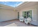 Inviting front porch with comfortable wicker seating, offering a relaxing outdoor space at 2113 Malcolm Dr, Palm Harbor, FL 34684