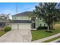 Exterior of a two-story home with an attached three-car garage, mature trees, and lawn at 2832 Brinley Dr, Trinity, FL 34655