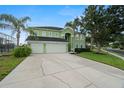 Home exterior with a three-car garage, mature palms, and green lawn at 2832 Brinley Dr, Trinity, FL 34655