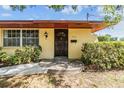 Inviting front entrance with a solid wood door, complemented by lush bushes and a concrete walkway at 309 Kenmore Rd, Brandon, FL 33511