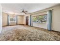 Bright living room with large windows, carpet, and a ceiling fan at 309 Kenmore Rd, Brandon, FL 33511