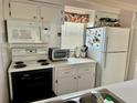 Bright kitchen features white appliances, ample cabinet space, and a window at 320 Medallion Blvd # G, Madeira Beach, FL 33708