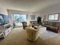 Cozy living room with wicker furniture, large windows, and a glimpse of the outdoor scenery at 320 Medallion Blvd # G, Madeira Beach, FL 33708