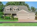 Charming home featuring a well-manicured lawn, lush landscaping, and a spacious three-car garage at 3406 Regner Dr, Plant City, FL 33566