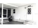 Front entrance featuring grill, steps and white door with diamond window insets at 37648 Campo Ave, Zephyrhills, FL 33541