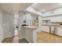 Bright kitchen featuring white cabinetry, stainless steel appliances, and a view of the living area at 402 S Armenia Ave # 139A, Tampa, FL 33609