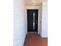 Modern black front door with a glass insert in a white brick facade with a red tile entry at 406 Bullard Pkwy, Temple Terrace, FL 33617