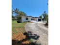 Wide angle view of house exterior with black garage door and long driveway at 406 Bullard Pkwy, Temple Terrace, FL 33617