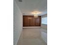 Bright living room with a decorative chandelier, tile floor, and brick accent wall at 406 Bullard Pkwy, Temple Terrace, FL 33617