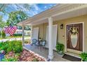 Inviting front porch with seating area, decorative wreath on the front door, and an American flag waving in the background at 4125 W Obispo St, Tampa, FL 33629