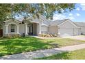Charming single-story home with a well-manicured lawn and a three car garage at 4401 Arranmore Cir, Valrico, FL 33596