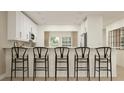Open kitchen featuring a white breakfast bar with modern stools and sleek cabinetry at 4511 S Manhattan Ave # 13, Tampa, FL 33611
