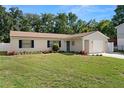 Lovely one-story home with a well-kept lawn, blooming flowerbeds, an attached garage, and a neutral exterior paint at 4549 Ontario Dr, New Port Richey, FL 34652