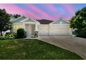 Charming single-Gathering home with a well-manicured lawn and a two-car garage against colorful sky at 4918 Lakeshore Oaks Ct, Tampa, FL 33624