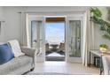 Living room showcasing ocean view from sliding glass doors leading to patio with table and chairs at 5042 Coquina Key Se Dr, St Petersburg, FL 33705