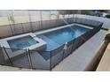 Backyard view of the private swimming pool and jacuzzi, secured by a safety fence and surrounded by patio pavers at 530 Severn Ave, Tampa, FL 33606