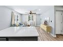 Bright living room with wood floors, modern furnishings, and natural light from large windows at 5632 Indiana Ave, New Port Richey, FL 34652