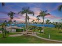 Community backyard featuring lush green space, mature palms and water views, with bench seating at 6021 Bahia Del Mar Cir # 239, St Petersburg, FL 33715