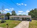 Charming single story home boasts a well-maintained lawn, mature landscaping and a covered carport at 6208 Florida E Cir, Apollo Beach, FL 33572