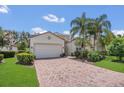 Charming home featuring a paved driveway, lush landscaping, a two-car garage, and well-maintained lawn at 6315 43Rd E Ct, Sarasota, FL 34243