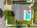Aerial view of a home with a pool, surrounded by lush landscaping and a well-maintained lawn at 6903 Cedar Ridge N Dr, Pinellas Park, FL 33781