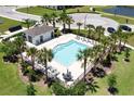 Community pool area with palm trees, lounge chairs and poolside clubhouse at 937 Royal Empress Dr, Ruskin, FL 33570