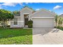 Attractive single-story home with a manicured lawn, complemented by an attached two-car garage at 9479 Southern Charm Cir, Brooksville, FL 34613