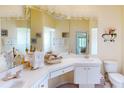 Bathroom featuring double sinks, vanity, white cabinets and a large mirror at 11368 Copley Ct, Spring Hill, FL 34609
