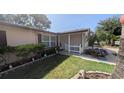 Inviting home entrance featuring a well-manicured lawn, decorative plants, and a white picket fence at 1538 S Lake Ave, Clearwater, FL 33756