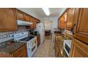 Functional kitchen with oak cabinets, granite counters, and white appliances at 1538 S Lake Ave, Clearwater, FL 33756