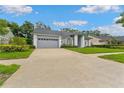 Exterior shot of a well-maintained home with a spacious driveway and lush landscaping at 15615 Indian Queen Dr, Odessa, FL 33556