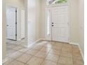Bright foyer features neutral tile flooring, and a sidelight window to the left of the front door at 15841 Pond Rush Ct, Land O Lakes, FL 34638