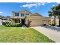 Charming two-story tan home with well-kept lawn and landscaping at 17510 Bright Wheat Dr, Lithia, FL 33547