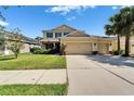 Two-story tan home with a three-car garage, manicured lawn, and palm trees at 17510 Bright Wheat Dr, Lithia, FL 33547
