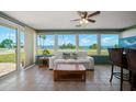 Bright sunroom featuring panoramic water views, comfortable seating, and tile floors at 1963 Edgewater Dr, Clearwater, FL 33755