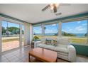 Bright sunroom featuring panoramic water views, comfortable seating, and tile floors at 1963 Edgewater Dr, Clearwater, FL 33755