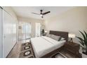A modern bedroom with neutral tones, a large bed, and sliding doors to a balcony or patio at 2002 Australia E Way # 66, Clearwater, FL 33763