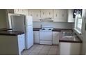 Functional kitchen with white cabinets, essential appliances, and ample counter space at 2603 Mary Sue Sw St, Largo, FL 33774