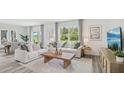Bright living room boasts hardwood floors, modern decor, large windows, and an adjacent dining area at 32702 Winterwood Blvd, Wesley Chapel, FL 33543