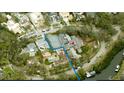 An aerial view shows a spacious estate featuring a tennis court, swimming pool, and access to the river at 5002 S Shore Crest Cir, Tampa, FL 33609