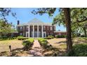 Stately home featuring large white columns, lush landscaping, and a brick walkway to the entrance at 5002 S Shore Crest Cir, Tampa, FL 33609